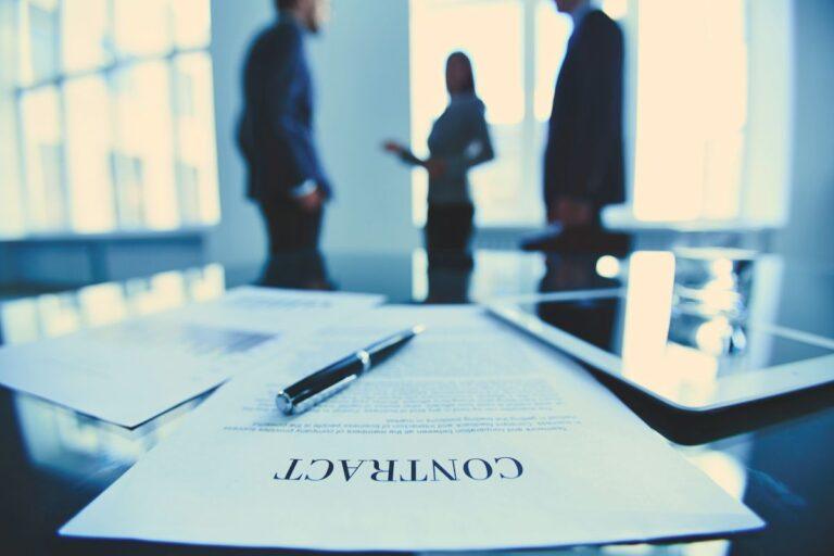 a contract paper lies on a table in front of two men and a women standing next to each other discussing the topic - do all contracts have a cooling-off period or not