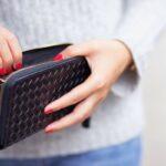a lady looking for money in her hand bag for spending